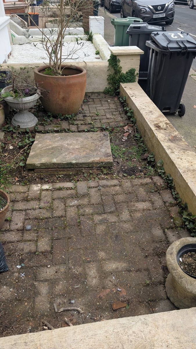 The same front garden cleared, showing the brick path and plant pots